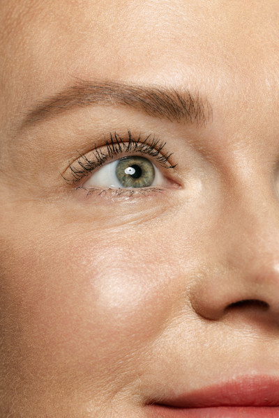 Close-up portrait of young woman's eyes with wrinkles. Female model with well-kept skin. Concept of women's health and beauty, cosmetology, cosmetics. Anti-aging.